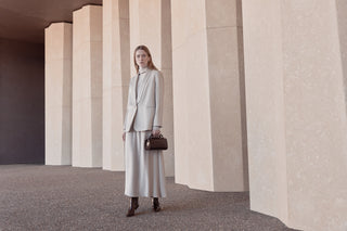 Woman with light grey satin blazer and grey velvet skirt