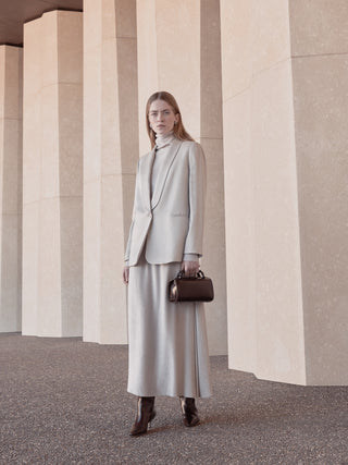 Woman with light grey satin blazer and grey velvet skirt