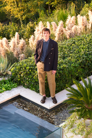 man with sand beige trousers, denim shirt and blue double breasted blazer