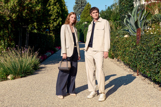 woman with blue denim and gold blazer, man with beige overshirt and trousers
