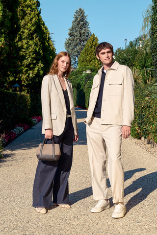 woman with blue denim and gold blazer, man with beige overshirt and trousers